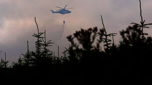 <p>Members of the Irish Air Corps provide aerial support in tackling a major wildfire as it continues to burn at Slievenamon in Co Tipperary. Picture: PA</p>