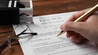 Woman signing Last Will and Testament at wooden table, closeup