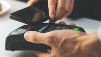 contactless payment - woman paying bill with smartphone at cafe