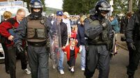 Royal Ulster Constabulary officers escort catholic