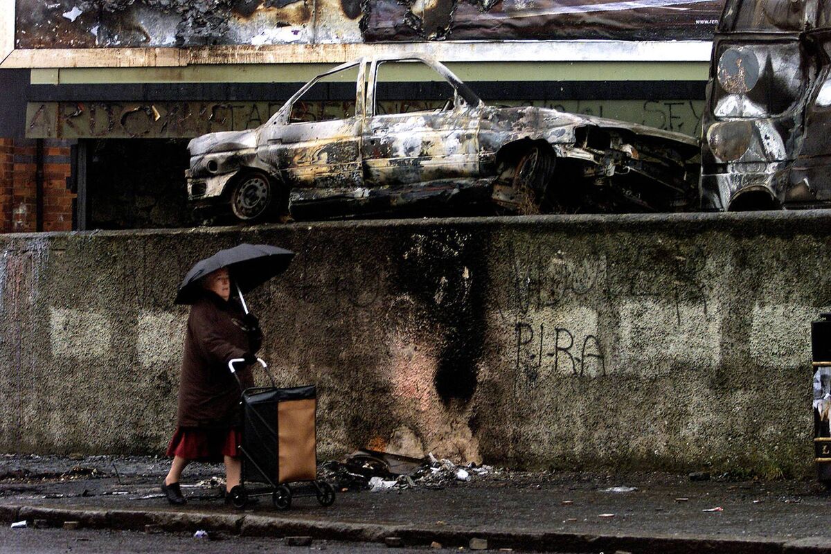 A woman walks through the nationalist Ardoyne area of Belfast after further violence in the city the previous night, January 11, 2002. Picture: BWP Media/Getty Images A woman walks through the nationalist Ardoyne area of Belfast after further violence in the city the previous night, January 11, 2002. Picture: BWP Media/Getty Images