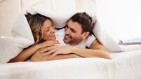 Affectionate couple talking in a bed during morning time.