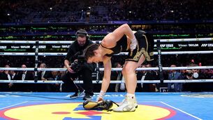 <p>LAYING A GLOVE: Katie Taylor lays her boxing gloves on the canvas for the final time to signify her retirement after victory Saturday night at Croke Park. Pic: Gary Carr, Inpho</p>