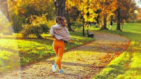 trendy female in fitness clothes in park jogging