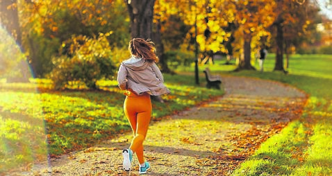 trendy female in fitness clothes in park jogging