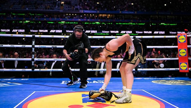 <p>CENTRE STAGE: Katie Taylor places her gloves in the centre of the ring following her undisputed super lightweight championship fight victory over Flora Pili at Croke Park. The moment capped a huge marketing coup for Lidl. Pic: Stephen McCarthy/Sportsfile</p>