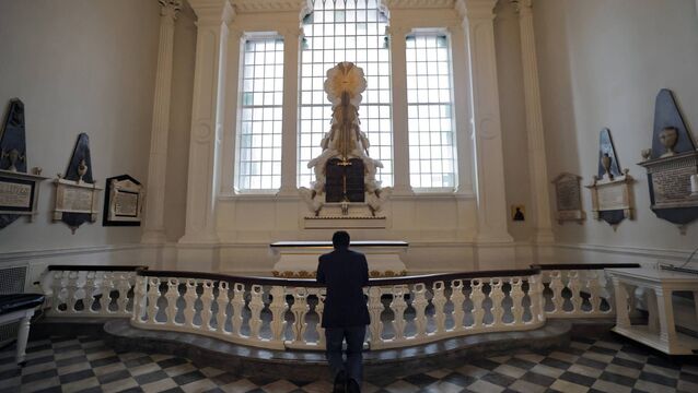 <p>A worshiper kneels in St Paul's Chapel which served as a sanctuary for rescue workers after 9/11. Photo: Mario Tama/Getty</p>