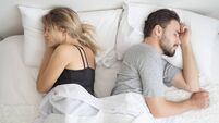 Young couple sleeping back to back in their bed