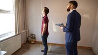 Male First Time Buyer Looking Around House For Renovation With Real Estate Agent