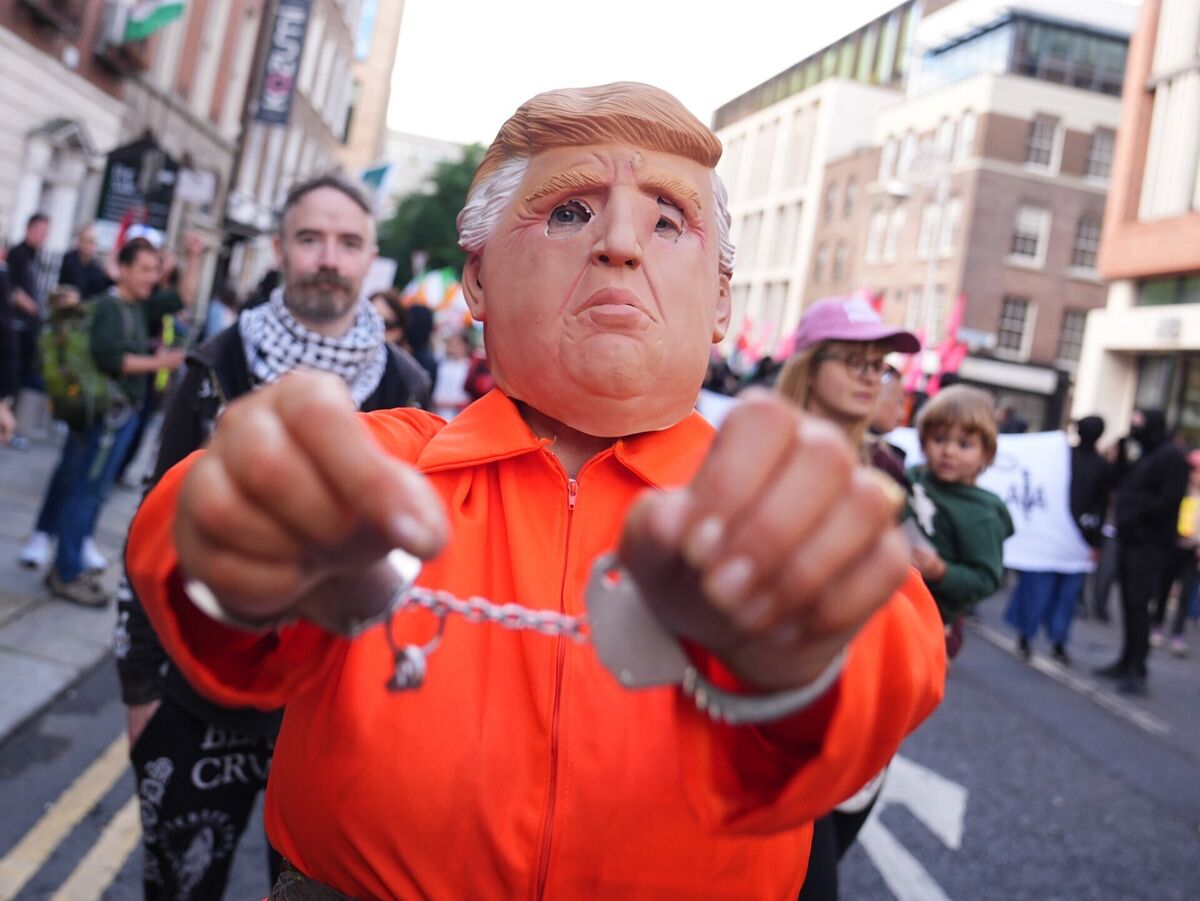 A person wearing a Donald Trump mask and dressed in an orange prison-style jumpsuit and in handcuffs at an anti-Trump protest march through Dublin city centre. Picture: James Manning/PA Wire A person wearing a Donald Trump mask and dressed in an orange prison-style jumpsuit and in handcuffs at an anti-Trump protest march through Dublin city centre. Picture: James Manning/PA Wire