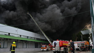 Firefighters put out a fire at warehouse stores after a Russian air attack in Odesa, Ukraine (Michael Shtekel/AP)