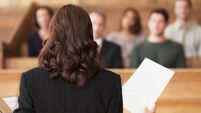 Lawyer holding document and speaking to jury in courtroom