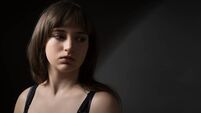Portrait of a beautiful teenage girl posing against a dark background in beauty style