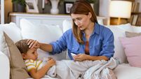 Mother checking temperature of her sick child.