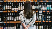 Woman customer looking at a rack of wine in supermarket