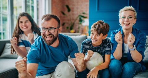 Family enjoys an exciting soccer match together at home, celebrating every goal with joy and enthusiasm