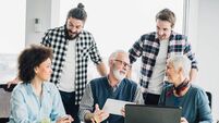 Senior business man holding tablet and having fun with coworkers