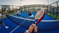 Friends playing padel on a blue outdoor court — energetic POV shot of group sport and recreation