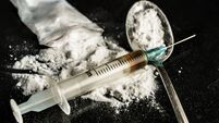 A drug syringe and a spoon with cooked heroin