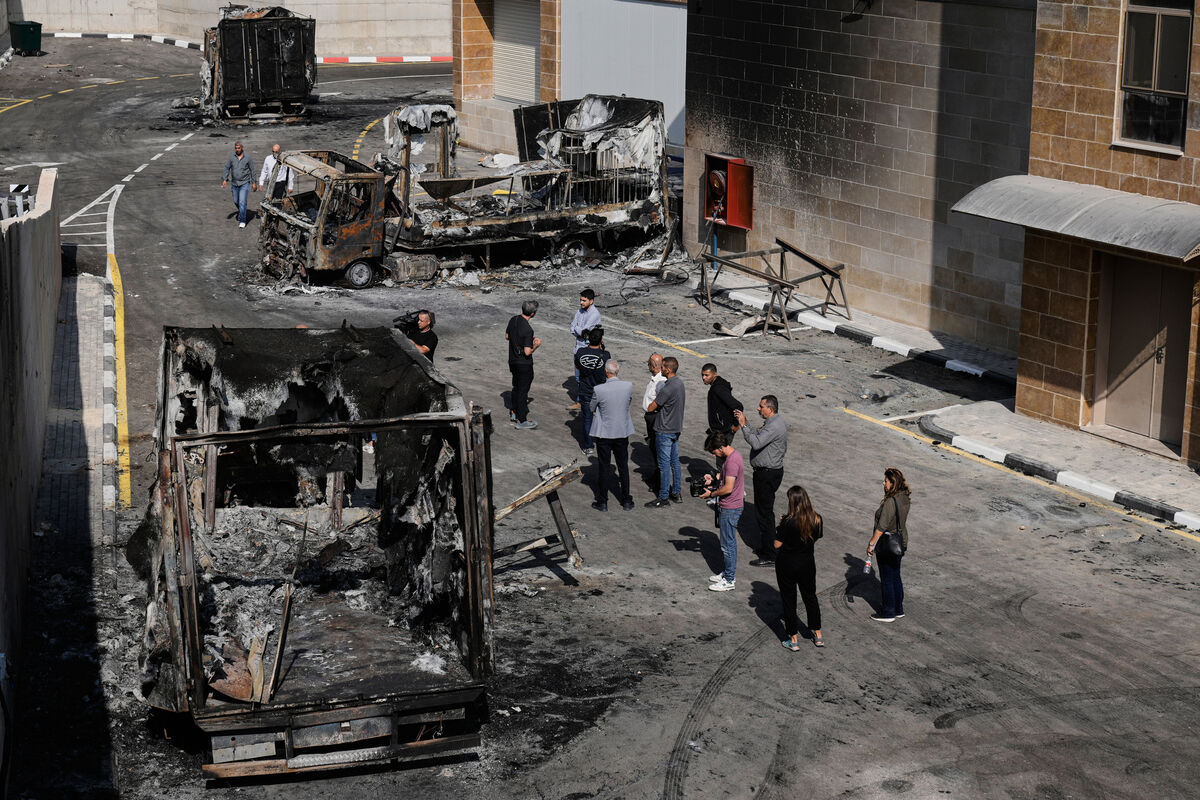 Palestinians and journalists survey damage in an industrial zone following an attack by Israeli settlers in the West Bank village of Beit Lid, near Tulkarm in November, 2025. Picture: Majdi Mohammed/AP Palestinians and journalists survey damage in an industrial zone following an attack by Israeli settlers in the West Bank village of Beit Lid, near Tulkarm in November, 2025. Picture: Majdi Mohammed/AP
