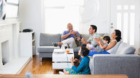 Family watching television together in living room