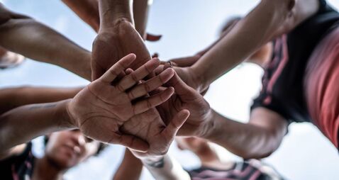 Close-up of female soccer team stacking hands in the field