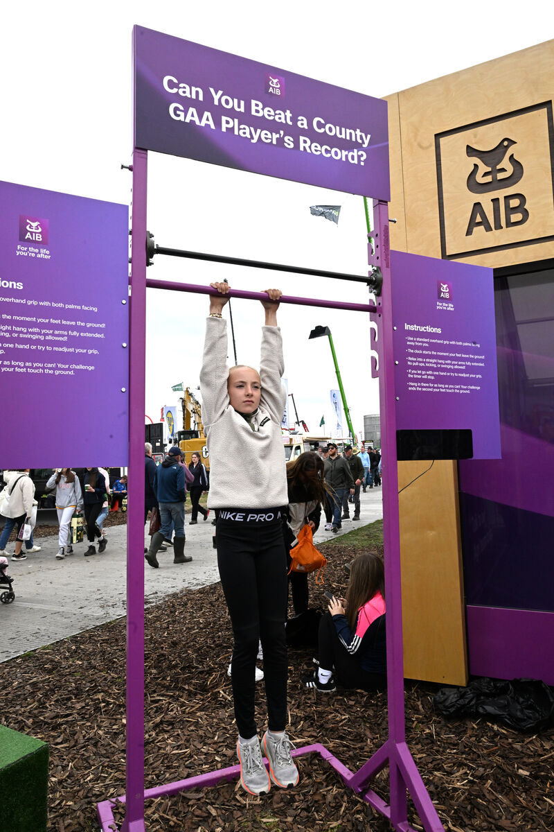 Muireann McDonagh from Co Clare tests her endurance as she takes the 'Hang Tough' challenge at the AIB stand at the National Ploughing Championships 2026. Picture: Larry Cummins Muireann McDonagh from Co Clare tests her endurance as she takes the 'Hang Tough' challenge at the AIB stand at the National Ploughing Championships 2026. Picture: Larry Cummins