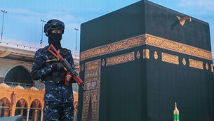 <p>A soldier from Yemen's Houthi rebels stands in front of a giant banner of the Kaaba. Picture: AP </p> <p>A soldier from Yemen's Houthi rebels stands in front of a giant banner of the Kaaba. Picture: AP </p>