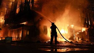 <p>A rescue worker puts out a fire at the Intrade trade center after a Russian drone strike on Zaporizhzhia, Ukraine, Monday, September 21. Picture: Kateryna Klochko/AP Photo.</p>