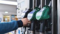 Refueling at a modern gas station with green fuel pumps and a customer filling their vehicle in a well-lit, organized space duri