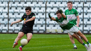 <p>Macroom’s Ultan Ó Tuama tries to stop a Callum Mulcahy shot for Diarmuid Ó Murchu in the Cork Premier 2 MFC final. Pic: Noel Sweeney</p>