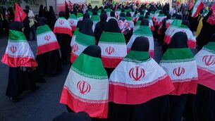 Women draped in Iranian flags march during the state-organised ‘Janfada’ or ‘Sacrifice for Iran’, a military-style parade in Tehran (Vahid Salemi/AP)