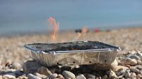 Image of flames on disposable barbecue, charcoal bbq on beach