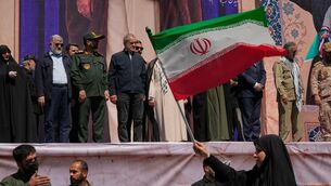 Iranian President Masoud Pezeshkian and other officials watch as a woman waves an Iranian flag (Vahid SalemiAP) Iranian President Masoud Pezeshkian and other officials watch as a woman waves an Iranian flag (Vahid SalemiAP)