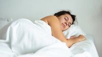 young pretty woman sleeping in bed with white sheets