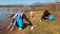 Family volunteering cleaning up plastic waste from lake