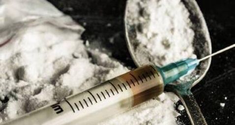 A drug syringe and a spoon with cooked heroin