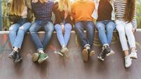 Group of diverse teenagers sitting together at a skatepark, enjoying friendship and casual youth culture outdoors