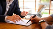 Closeup lawyer or insurance agent pointing at contract showing male client where to signature sign