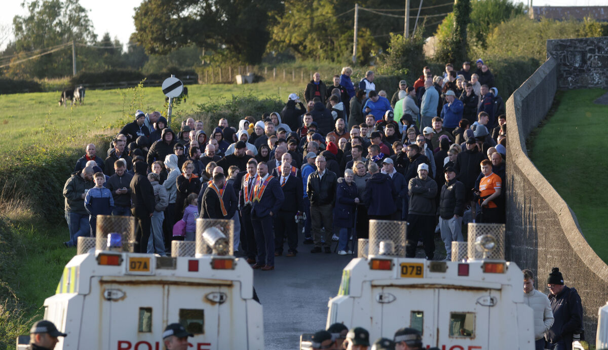 Orange men gather near Drumcree Church as police form a barricade to prevent them entering the Garvaghy Road. Picture: PA Orange men gather near Drumcree Church as police form a barricade to prevent them entering the Garvaghy Road. Picture: PA