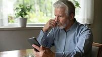 Close up stressed unhappy mature man looking at phone screen