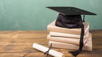 Graduation!  Cap, motarboard and tassel with dilploma on desk. Education.