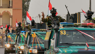 Iraqi security officers ride on vehicles decorated with national flags (Hadi Mizban/AP) Iraqi security officers ride on vehicles decorated with national flags (Hadi Mizban/AP)