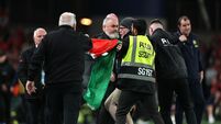 A pitch invader is removed by security as he unveils a Palestine flag 1/10/2026