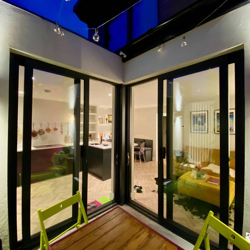 Something new (furniture), something old (pots and crockers), something black (windows and kitchen), something gold (frames and side table). Something new (furniture), something old (pots and crockers), something black (windows and kitchen), something gold (frames and side table).