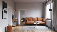 A cozy living room with a brown sofa, wooden floor