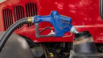 Diesel fuel nozzle fueling farm tractor. Farming input costs, fuel price increase and emissions pollution concept.