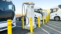 Electric truck charging station with yellow safety bollards in a fleet parking lot