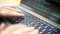 A person's hands are typing on a laptop displaying hacker code, highlighting issues of cyber security, privacy threats, and serv