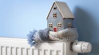 House model wrapped in scarf on radiator winter energy, heating and insulation background